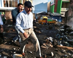 Danilo Medina camina por los escombros dejados por el fuego que destruyo el mercado publico de Azua